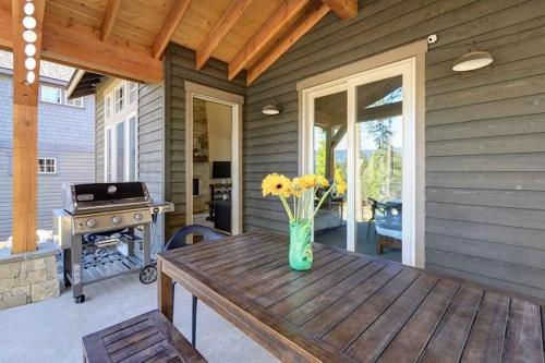 a vase of flowers sitting on a wooden table on a patio at Suncadia 3 Bdrm Family Home with Spectacular Views in Cle Elum