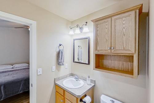 een badkamer met een wastafel, een kast en een bed bij Nehalem Nook in Albany