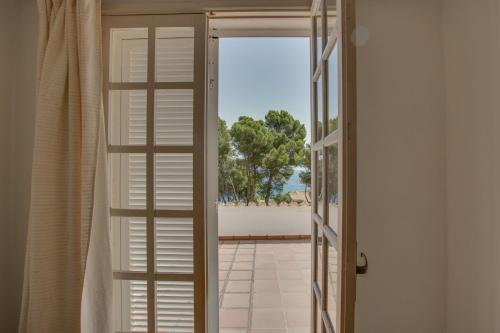 an open door to a balcony with a view of the ocean at Villa Cala Padri Seafront home in Capdepera