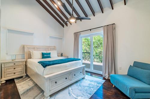 a bedroom with a bed and a couch at Casa De Moya at Mahogany Bay & The PoolClub in San Pedro
