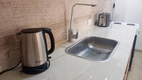 a coffee pot sitting on a counter next to a sink at Duplex Atenea in Chivilcoy