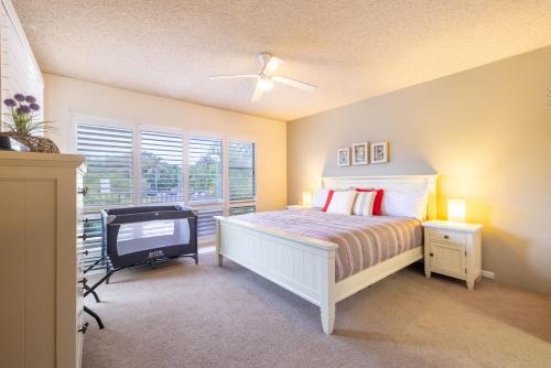 Un dormitorio con una cama y un televisor. en 14 The Dunes large unit with pool tennis court and directly across from Fingal beach, en Fingal Bay