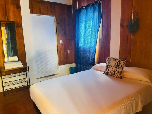 a bedroom with a white bed and a window at Blue House in Puerto Escondido