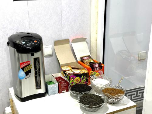 une cafetière assise sur un comptoir avec de la nourriture dans l'établissement MIRKA HOTEL LUX, à Samarcande