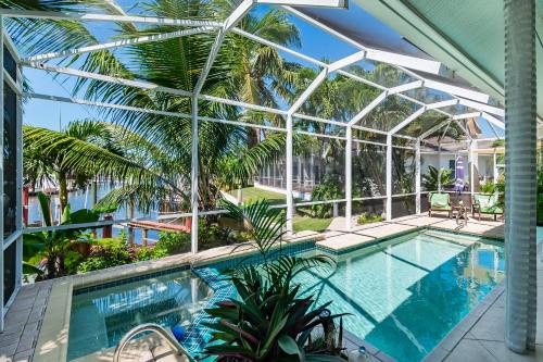 an indoor swimming pool with a glassconservatory with a swimming poolvisor at Perfect Blend of Elegance and Comfort I Captivating Home For Idyllic Retreat in Marco Island