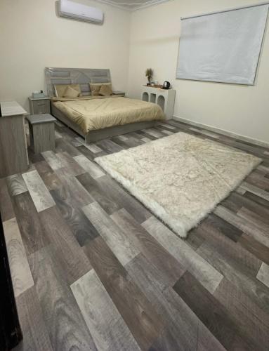 una camera con letto e pavimenti in legno di غرفه a Hail