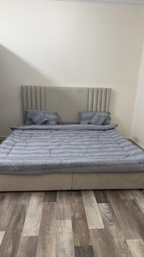Bett in einem Schlafzimmer mit Holzboden in der Unterkunft غرفه in Ha'il
