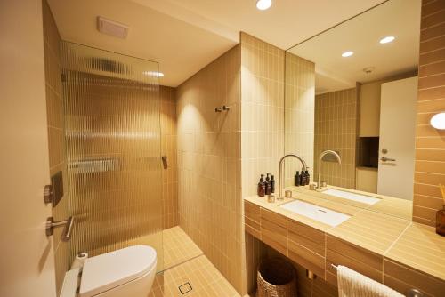 a bathroom with a toilet and a sink and a mirror at Burleigh Beach Tower in Gold Coast