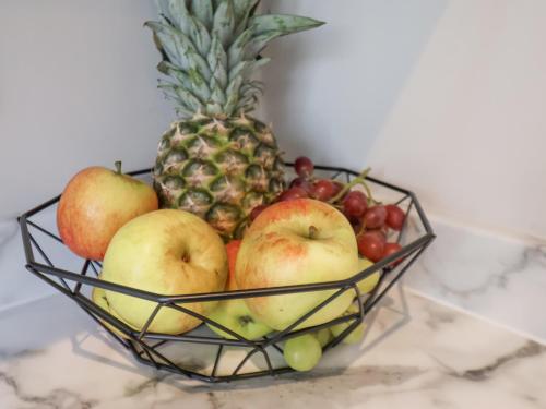 a basket of fruit with a pineapple and other fruits at Apt 9 Hunter's Quay in Bridlington