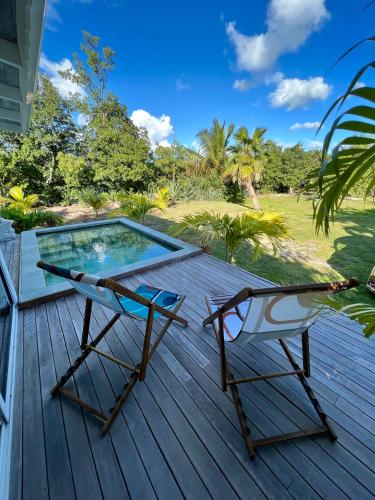 a deck with two chairs and a swimming pool at Villa Branca - Les Terres Basses in Marigot