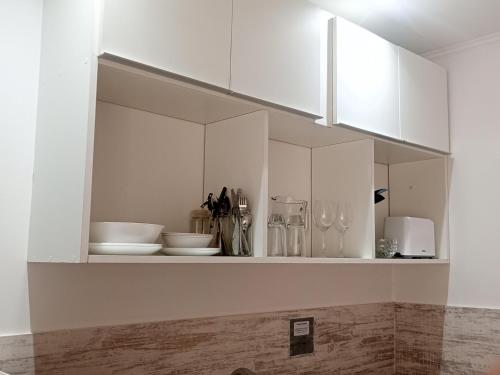 una cocina blanca con armarios y utensilios blancos en Monoambiente Atenea B en Chivilcoy