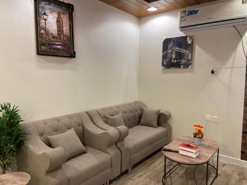 a living room with a couch and a table at بيتي بلس للغرف الفندقية- مدخل مستقل in Riyadh Al Khabra