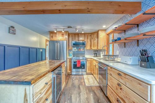 a kitchen with wooden cabinets and stainless steel appliances at The Monk's Cottage-White Mountains, Pet Friendly in Woodstock