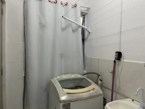 a small bathroom with a toilet and a shower at Apartamento no Centro de Blumenau in Blumenau