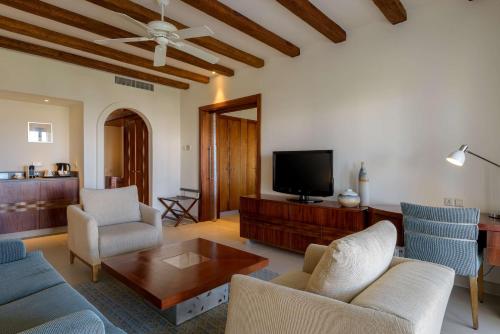 a living room with a couch and chairs and a tv at Hilton Marsa Alam Nubian Resort in Abu Dabab