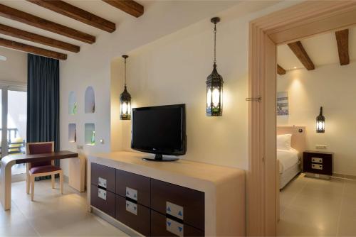 a living room with a tv and a bedroom at Hilton Marsa Alam Nubian Resort in Abu Dabab
