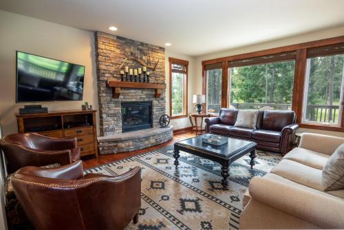 ein Wohnzimmer mit Ledermöbeln und Kamin in der Unterkunft Suncadia 4 Bed Fairway View Lodge in Cle Elum