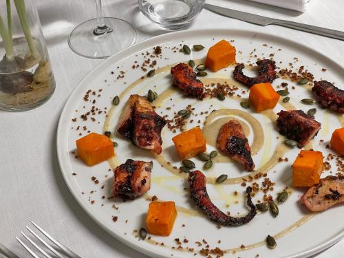 a plate of food with meat and vegetables on a table at Hotel Villa Policreti in Castello dʼAviano