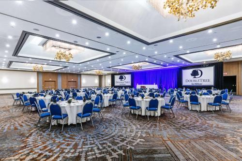 a banquet hall with tables and chairs and a stage at DoubleTree by Hilton Tulsa - Warren Place in Tulsa