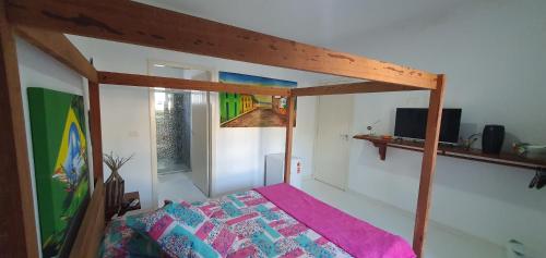ein Schlafzimmer mit einem Bett mit einem hölzernen Baldachin in der Unterkunft Linda suíte in Porto Seguro