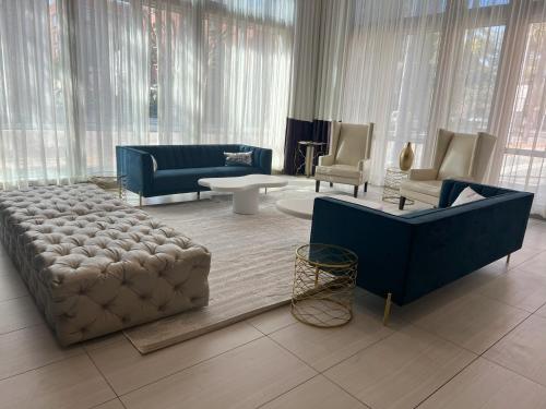 a living room with a large couch and chairs at TRYP by Wyndham Savannah in Savannah