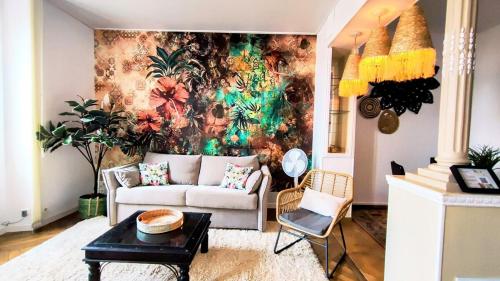 sala de estar con sofá y mural en la pared en KOSY Spa, Les Princes, en Cannes