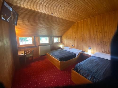 a room with two beds and a desk in it at HOTEL ITALIA in Forni di Sopra