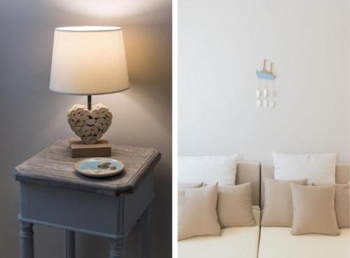 a table with a lamp and a couch with pillows at Villa Nausithoe 1 Paros in Logaras