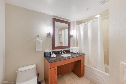 a bathroom with a sink and a mirror and a toilet at 15th Floor Luxury Suite at Trump Int Resort in Sunny Isles Beach