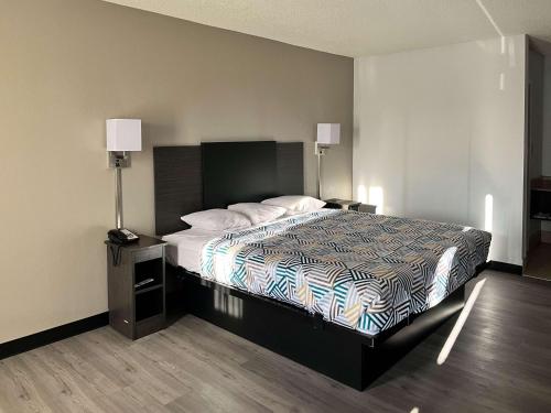 1 dormitorio con 1 cama, 2 mesitas de noche y 2 lámparas en Motel 6 Montgomery, AL - Eastern Blvd. en Montgomery