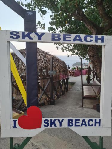 a sign that says sky beach sky beach at Sky Beach Rooms in Lucea