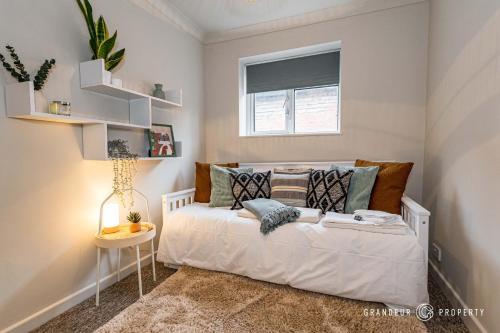 um quarto com uma cama branca e uma janela em New! Stylish 2 bed flat with parking near beach - Parkstone Central em Parkstone