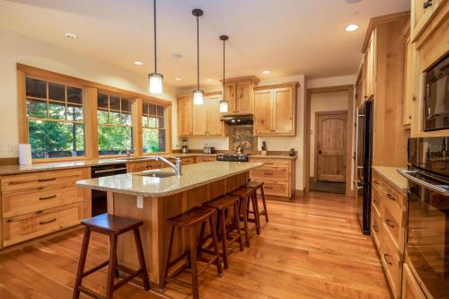 a kitchen with wooden cabinets and a large island with bar stools at Suncadia 5 Bdrm Home Boasting 3,000 Square Feet of Fun for Families in Cle Elum