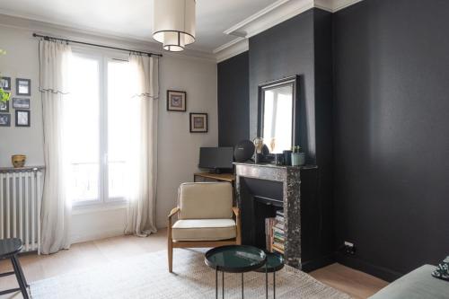 een woonkamer met een open haard en een spiegel bij Cozy 30 m love nest in Levallois-Perret in Levallois-Perret