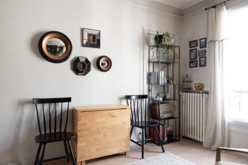 een woonkamer met 2 stoelen en een houten dressoir bij Cozy 30 m love nest in Levallois-Perret in Levallois-Perret
