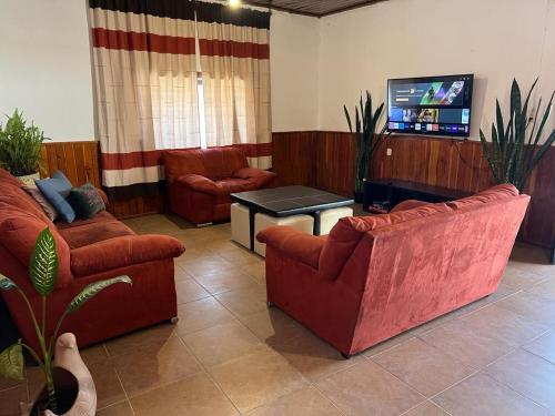 a living room with couches and a flat screen tv at Casa en el centro de San Cristóbal in San Cristóbal de Las Casas