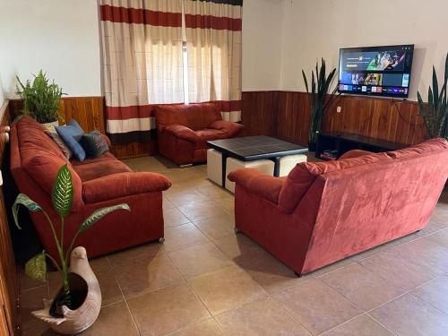 a living room with two couches and a tv at Casa en el centro de San Cristóbal in San Cristóbal de Las Casas