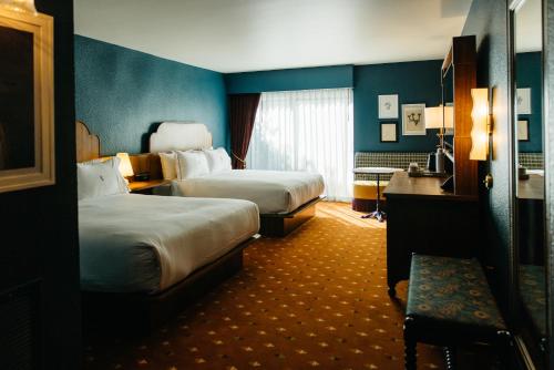 two beds in a hotel room with blue walls at The Hotel Chalet at The Choo Choo in Chattanooga