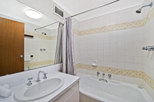 a bathroom with a sink and a bath tub at Akuna 14 6 Joffre Street in Port Macquarie