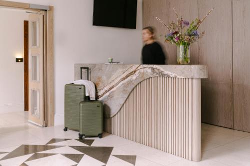 a woman standing next to a counter with a suitcase at Sonder The Voyage in London