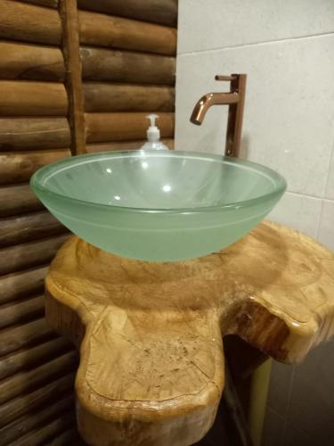 a bathroom with a glass sink on top of a wooden table at Hotel Campestre Cabañas de la Sierra Nevada de El Cocuy in Panqueba