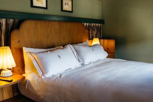 a bedroom with a bed with white pillows and two lamps at The Hotel Chalet at The Choo Choo in Chattanooga