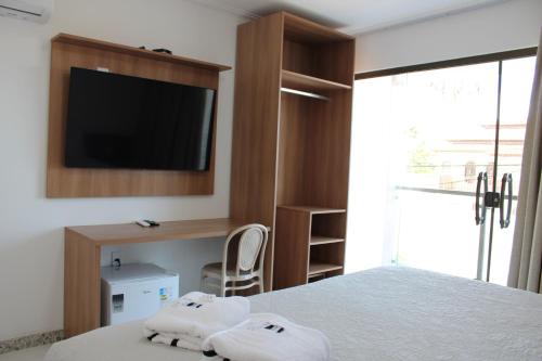 een slaapkamer met een bed en een tv aan de muur bij Serra Plaza Premium in Serrinha