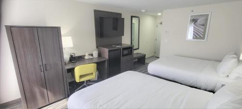 ein Hotelzimmer mit einem Bett und einem Schreibtisch mit einem TV in der Unterkunft Best Western Heartland Inn in Mattoon
