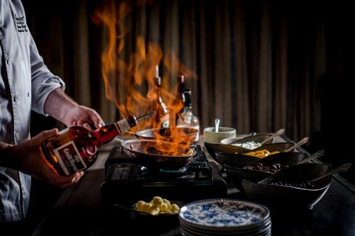 a man is cooking food on a table with flames at Fairmont Hotel Macdonald in Edmonton