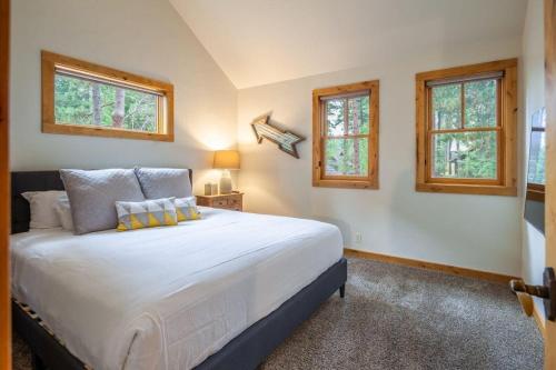 a bedroom with a large white bed with two windows at Suncadia 5 Bed Refined Alpine Home in Cle Elum