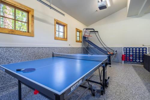 a ping pong table in a room with a net at Suncadia 5 Bed Refined Alpine Home in Cle Elum
