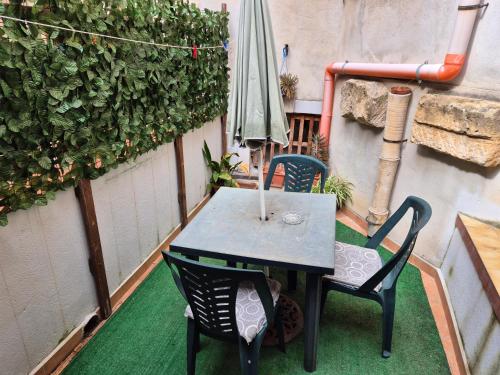 a table and chairs on a patio with an umbrella at Apartment Trapani's heart in Trapani