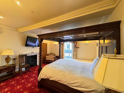 a bedroom with a large bed and a fireplace at Villare Hitchin Town Centre in Hitchin