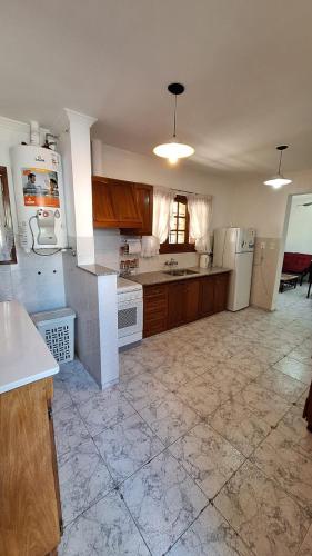 uma cozinha com electrodomésticos brancos e armários de madeira em La casa de la Nona em San Rafael